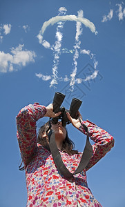 女人用望远镜看天空上一美元符号图片
