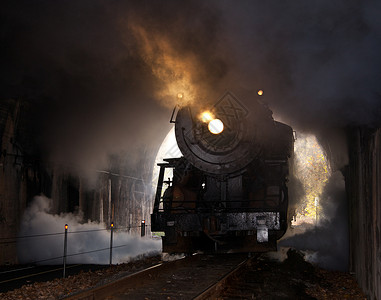 旧的蒸汽列车拖入一条隧道堵塞蒸汽和烟雾图片