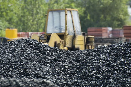 背景上的煤堆和挖掘器图片