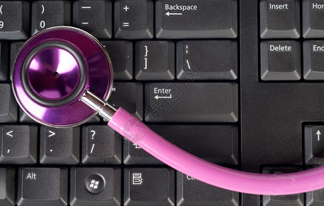 计算机键盘上的粉色听诊器背景图片