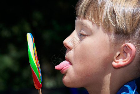 一个男孩用舌头舔棒糖男孩图片