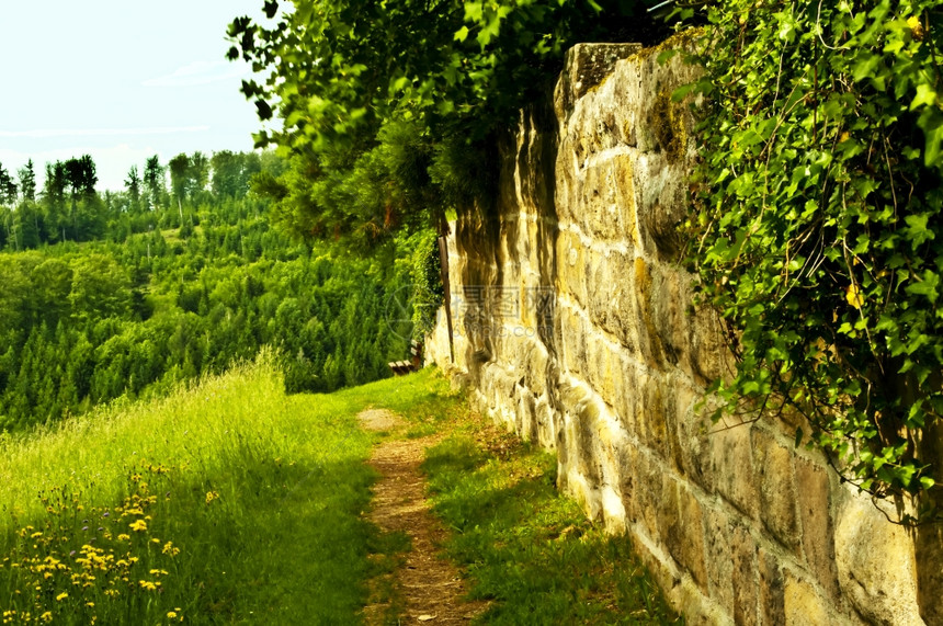 旧古老修道院墙上的公园长椅图片