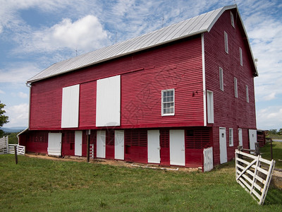 红谷仓红漆的色木制谷仓在农场上用我们传统风格的白色门背景