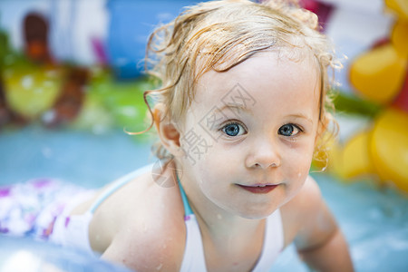 在游泳池的金发小女孩柔软的焦点图片