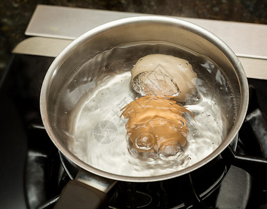 沸水中的两个鸡蛋不锈钢筋中的两个鸡蛋加在煤气桶中的两个不锈钢锅中的两个鸡蛋背景图片
