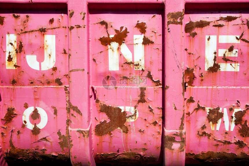 生锈和在卡车金属表面用字母剥粉色油漆图片