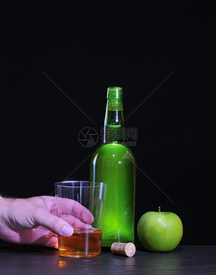 亚述苹果酒和手与黑色背景图片