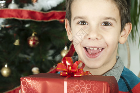 快乐的孩子在圣诞树前接受礼物图片