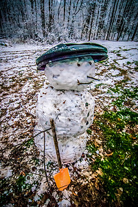 后院里用雪和树叶堆成的脏雪人图片