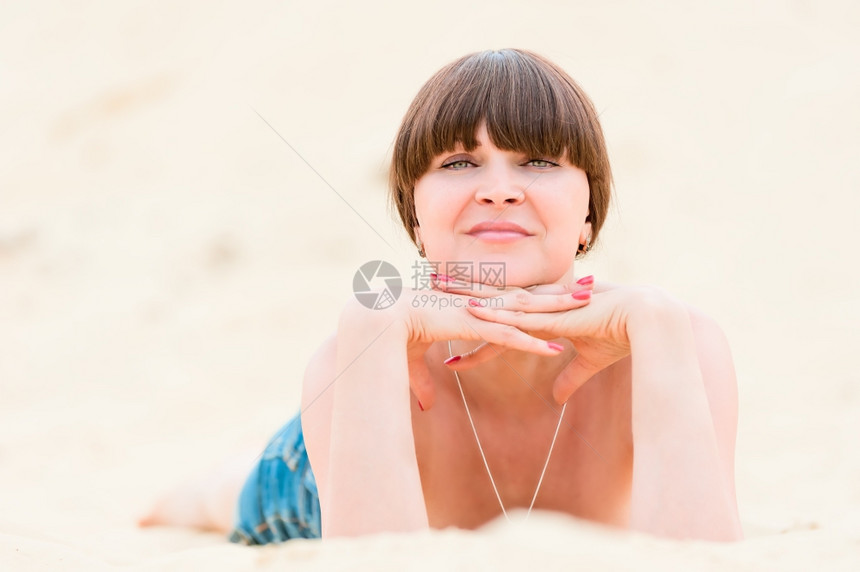 身穿牛仔短裤的女孩在沙滩上图片