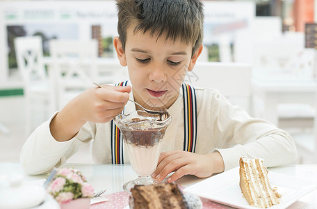 巧克力奶昔儿童在餐桌上吃牛奶和巧克力昔背景