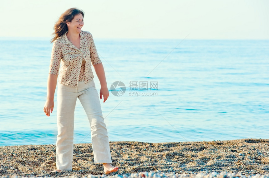 光脚在海滩上行走的女人图片