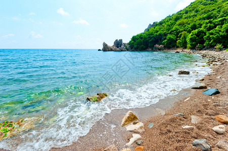岩石沙滩绿山海水的阴凉域图片