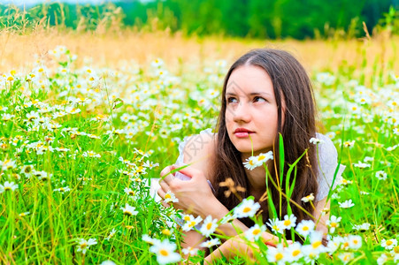 美丽的女人躺在绿地上花朵茂盛背景图片