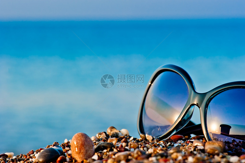 沙滩上的太阳镜躺在湿石子的沙滩上图片