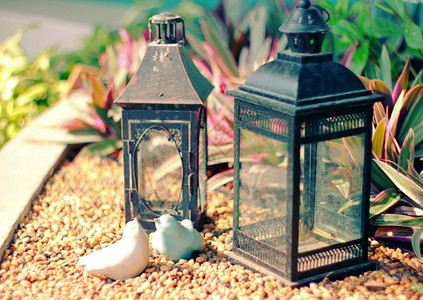 装饰花园的陶瓷鸟和旧灯具有反转过滤效应背景图片