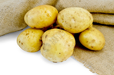 一堆黄色的土豆管子白色背景的布袋被孤立图片