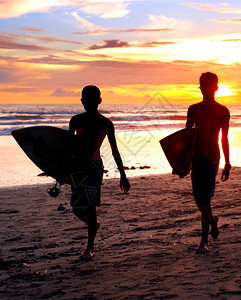 在巴厘岛海边的两个冲浪者图片