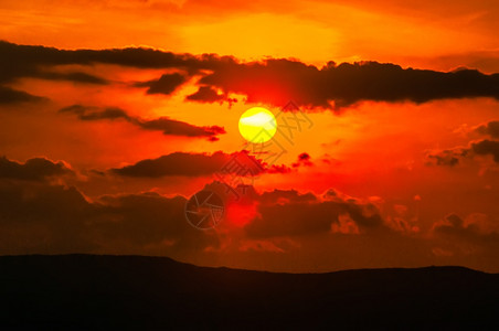 橙色的日落天空和山谷的云图片