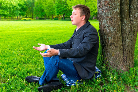 公园里商人坐在树旁休息图片