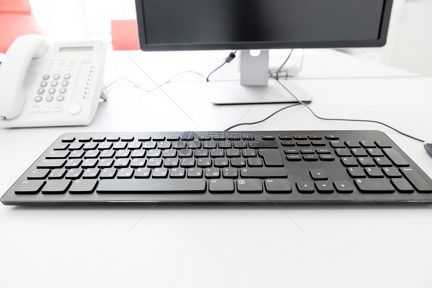 办公室管理器桌上黑键盘的图片
