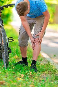 自行车和膝部受伤的年轻人图片