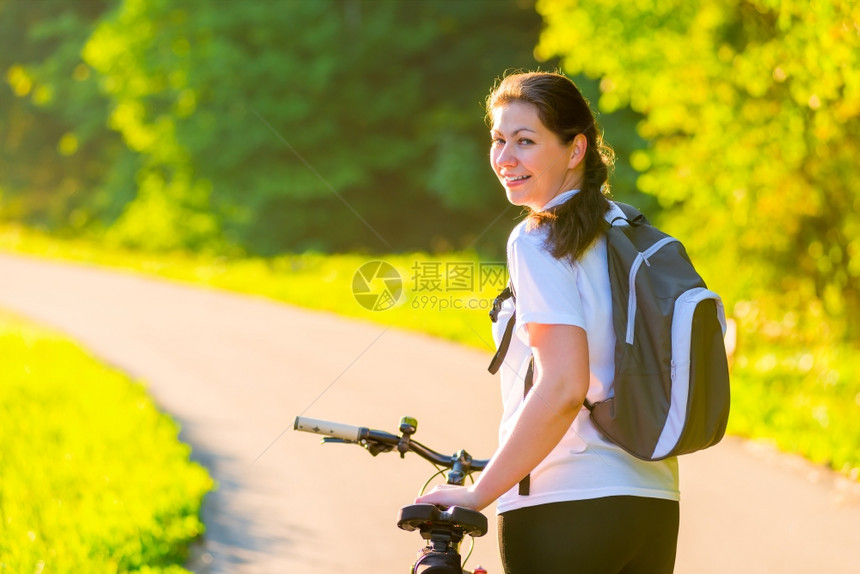 年轻女人手扶自行车停顿图片