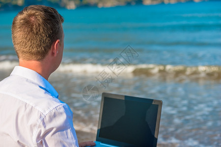 在海后视线用笔记本电脑的人背景图片