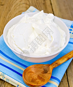 白碗里厚的酸奶勺子木板上餐巾纸图片