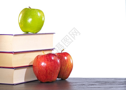 3个苹果和本书放在桌子上图片