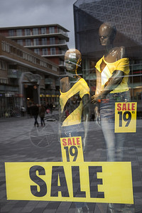 时装商店的销售窗和购物者的反光图片