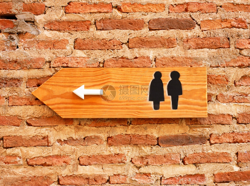 砖墙上的厕所标志和方向图片