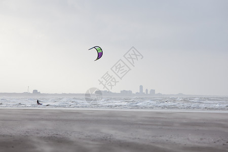 风沙滩后面的Zandvort风筝冲浪机和散光灯图片