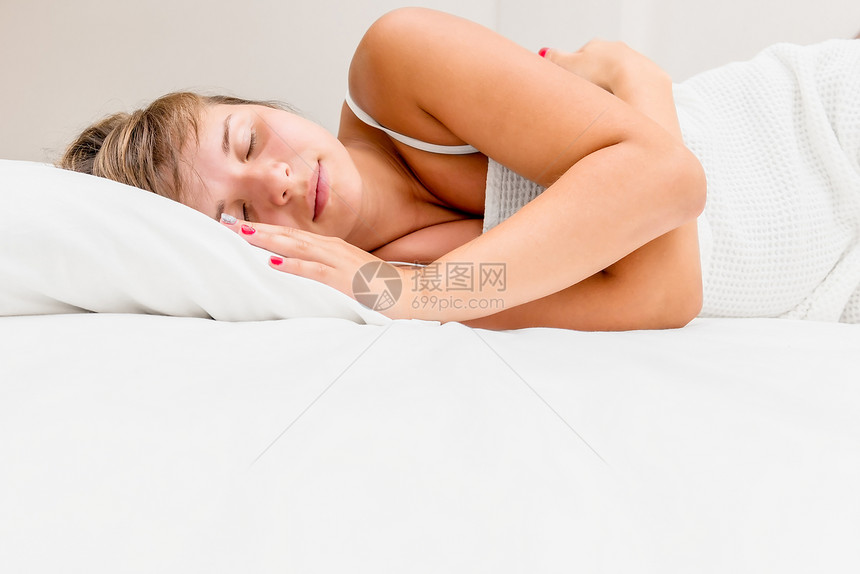 睡在白床上的年轻女人图片