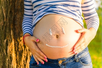 孕妇的肚子上涂着快乐的笑容图片