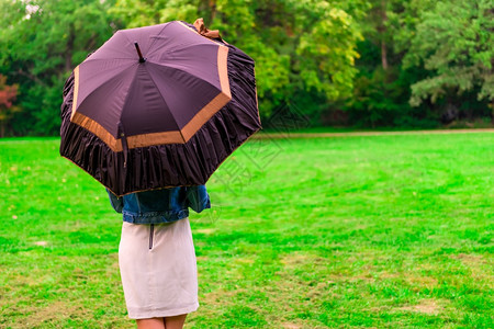 紫色雨伞站在露天伞下草原上的女人背景