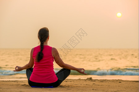 女运动员穿服在日落做瑜伽图片