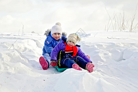 两个小女孩冬天在雪上橇图片