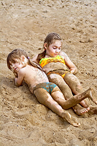 两个女孩躺在河边沙滩上图片