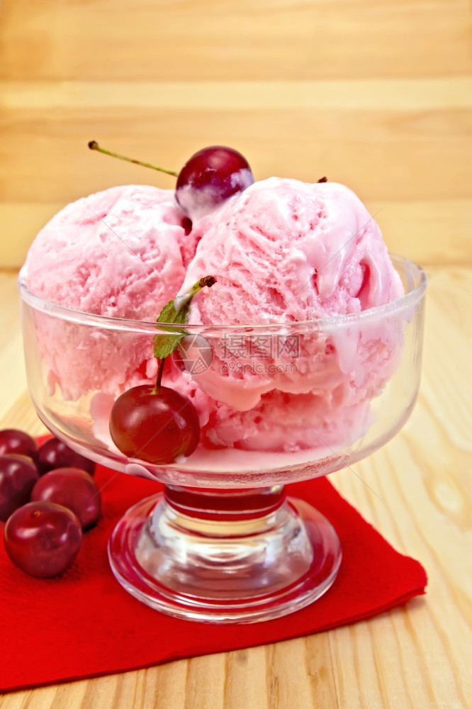 一个玻璃碗中的樱桃冰淇淋红纸巾上的浆果木板背景图片