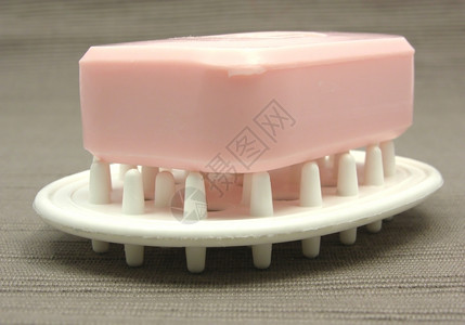 灰色背景的肥皂盘上粉红色肥皂背景图片