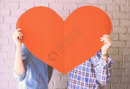 一对夫妇持有手工造纸心脏并具有反转过滤效果图片