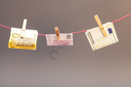 夹在绳子上的钱在灰色背景上孤立的衣和欧元货币背景