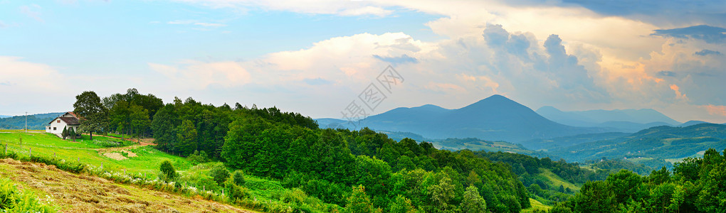 波斯尼亚风景白的房屋山岳树木和草背景