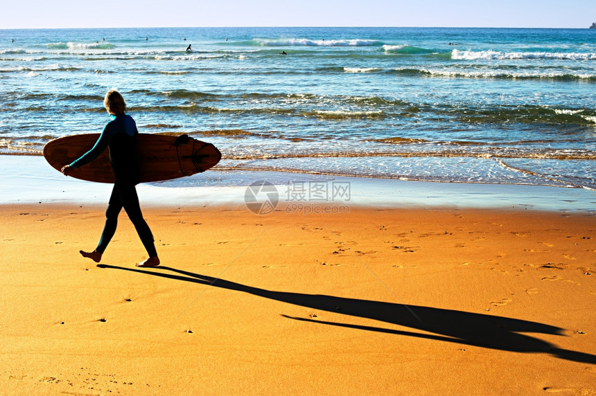 女人在海滨散步的冲浪板图片