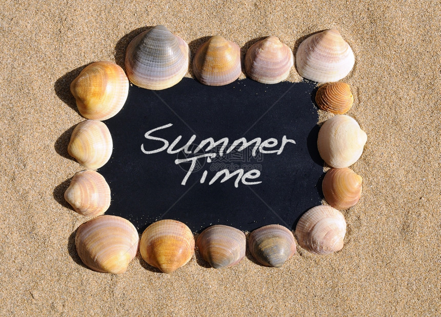 海滩沙上的黑板写着夏日的短语图片