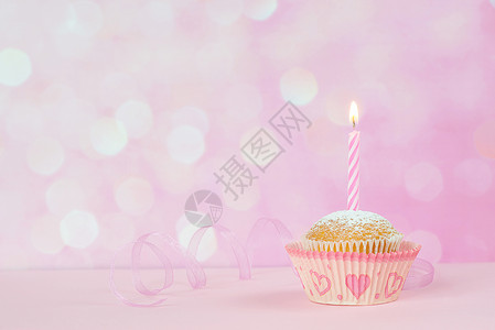 小纸杯蛋糕粉红背景的一根烧焦蜡烛图片