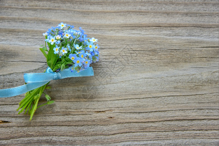 木板上绑蓝丝带的花束图片