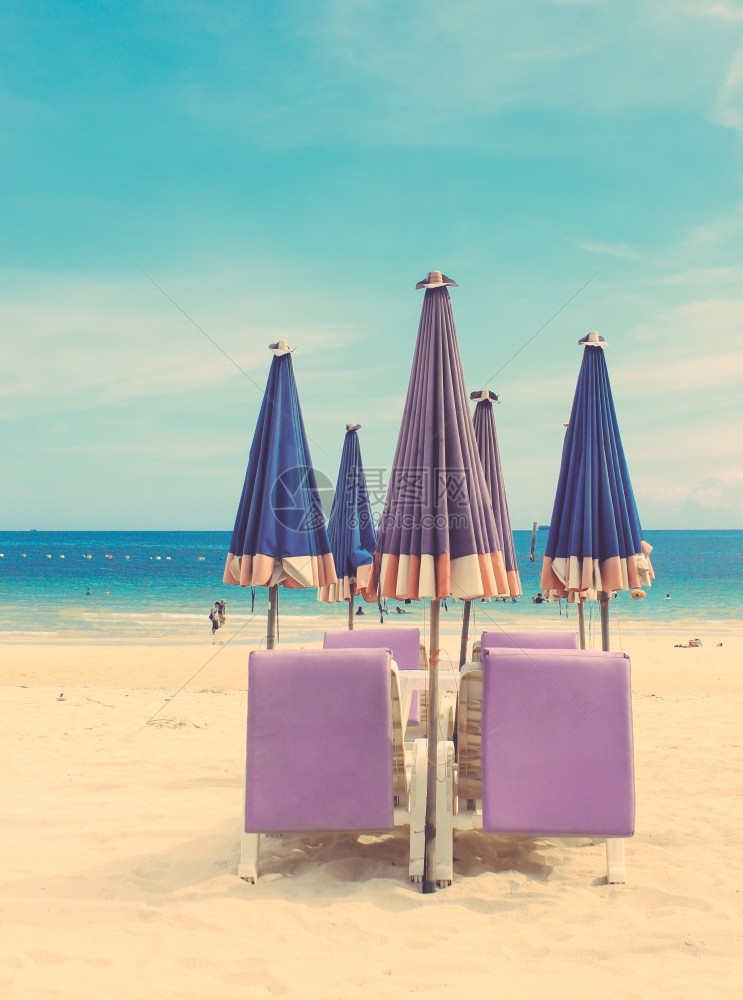 热带沙滩上的椅和雨伞具有追溯过滤效应图片