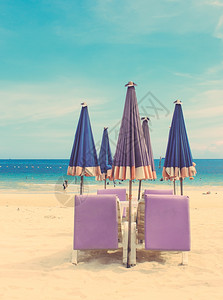 热带沙滩上的椅和雨伞具有追溯过滤效应图片